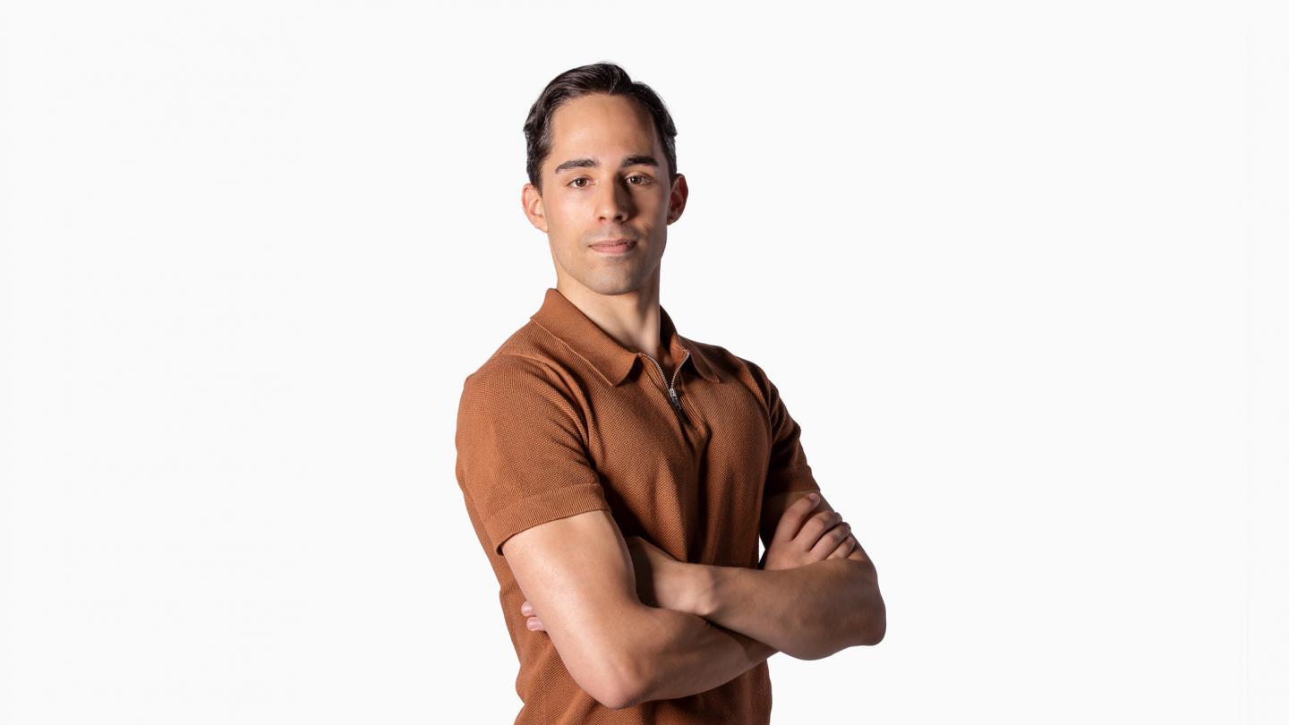 Headshot of male dancer in orange polo shirt