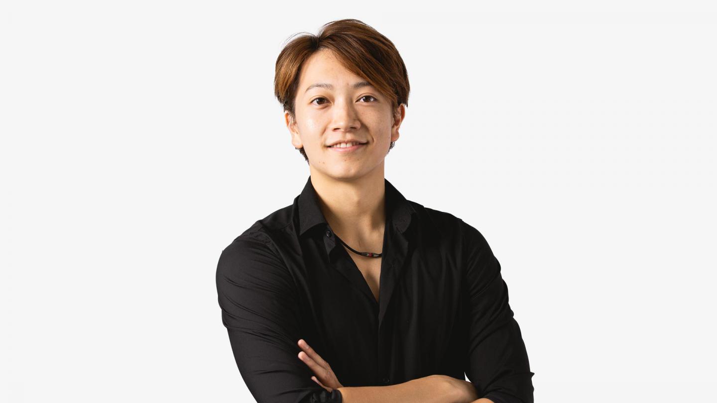 A headshot of a man looking forward in a black shirt