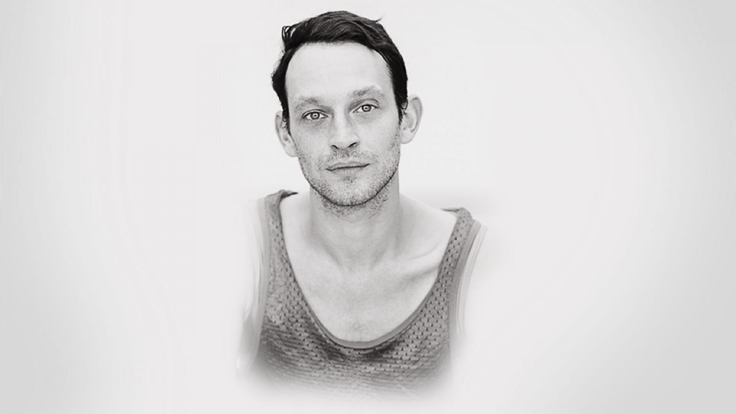 Monochrome image of male dancer with light skin and short dark hair