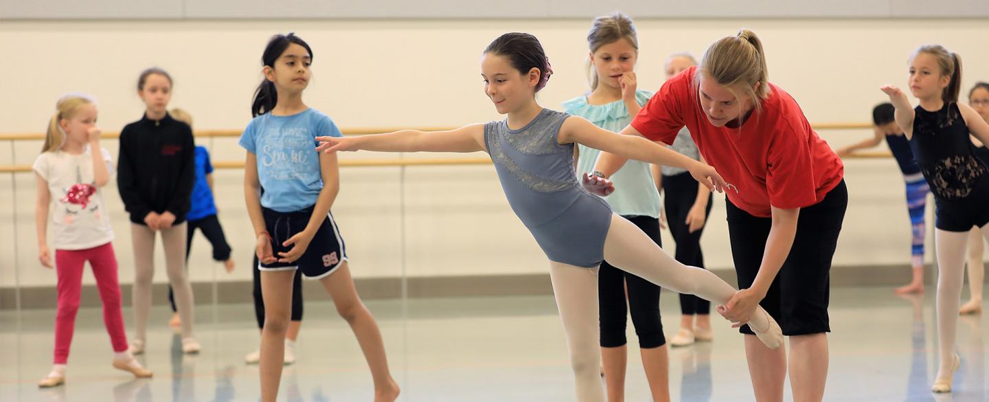 teacher coaching child on dance position