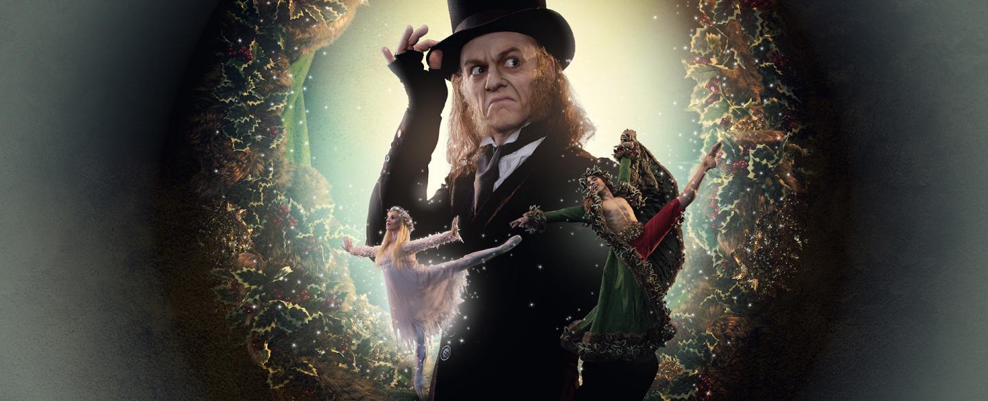 Poster image of A Christmas Carol with Scrooge in his top hat looking mean and in front of him the ghosts of Christmas past and present.