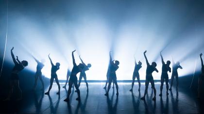 Northern Ballet dancers perform in unison through a flood of light. Photo Emma Kauldhar.