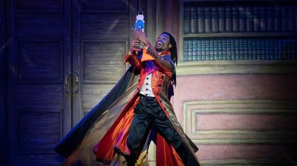 Uncle Drosselmeyer holds the toy nutcracker high