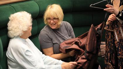 Two ladies sat touching a costume