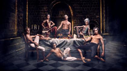 A group of dancers sit around a table, relaxing after a party