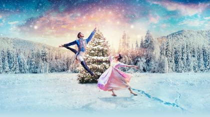 Clara and the Nutcracker Prince dancing in the snow in front of a Christmas tree