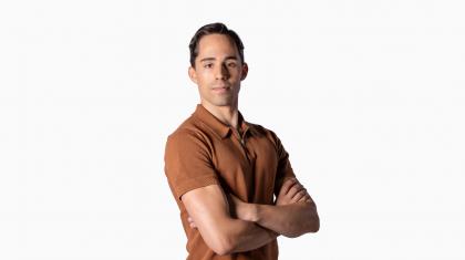 Headshot of male dancer in orange polo shirt