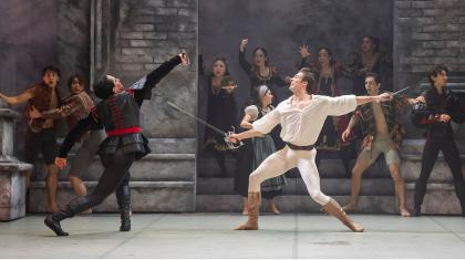 Two dancers with swords jousting on stage