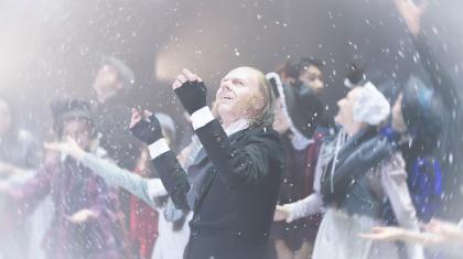 A dancer in Dickensian costume stood on stage marvelling at the snow falling